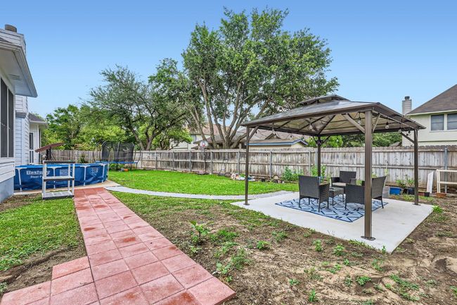 Fenced backyard with a trampoline, a patio area, and a gazebo | Image 27