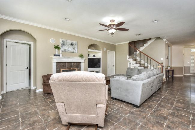 Lovely rustic hard tile flooring and crown molding runs throughout the first floor living areas! | Image 9