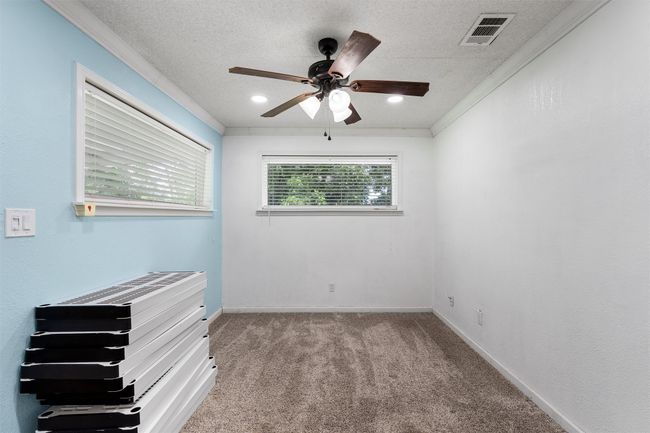 BONUS room featuring a ceiling fan, carpet flooring, crown molding, and a textured ceiling | Image 22