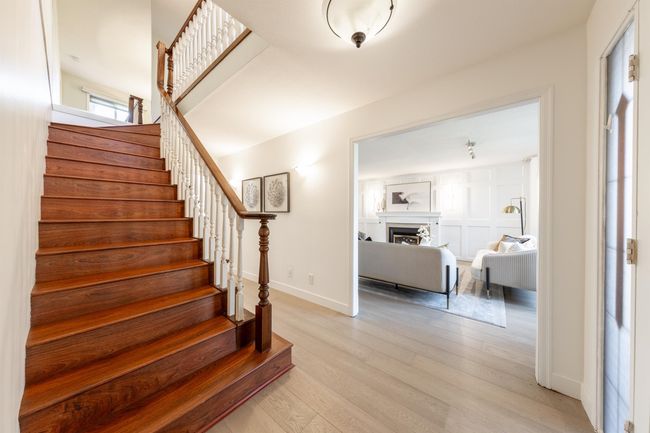 Staircase featuring baseboards, a fireplace, and wood finished floors | Image 7