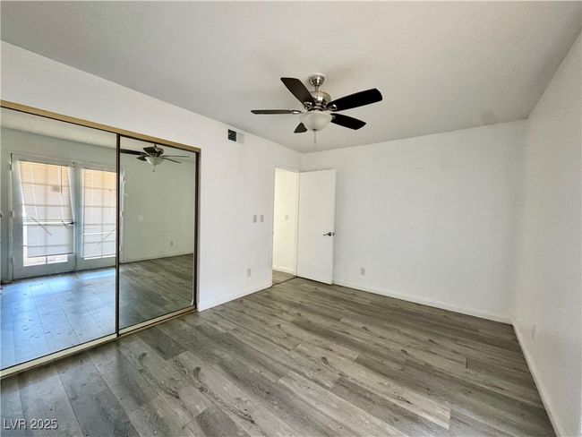 Unfurnished bedroom with wood finished floors, baseboards, ceiling fan, and a closet | Image 18