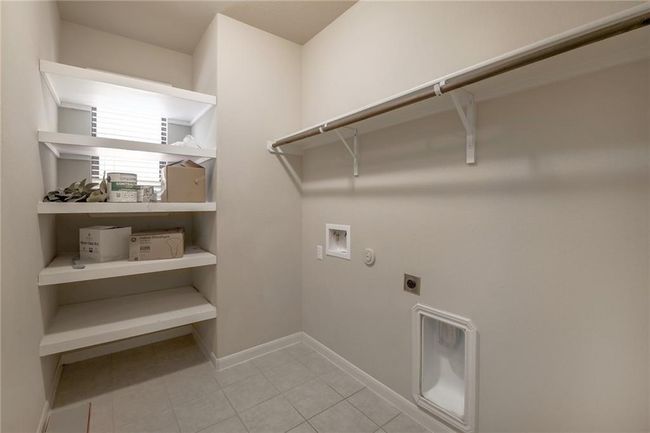 Laundry room with hookup for an electric dryer, hookup for a washing machine, light tile patterned floors, and gas dryer hookup | Image 28