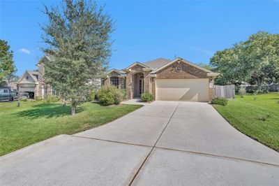 A view of the home from the street featuring one of two mature trees in the front yard providing a little privacy and shade. | Image 3