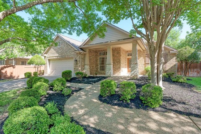 View of front of house with brick siding, an attached garage, fence, and driveway | Image 4