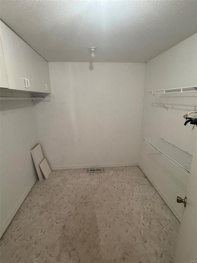 Laundry room with cabinets, light colored carpet, and a textured ceiling | Image 19