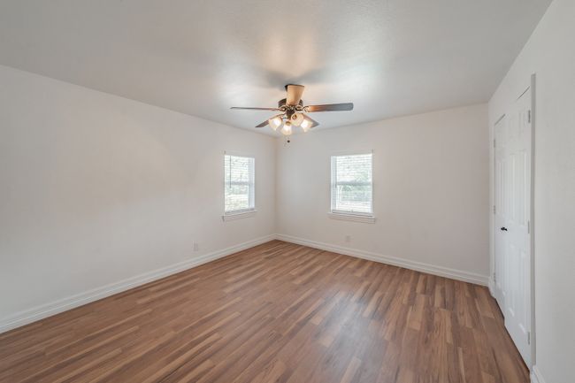 Unfurnished bedroom featuring wood finished floors, baseboards, and ceiling fan | Image 7