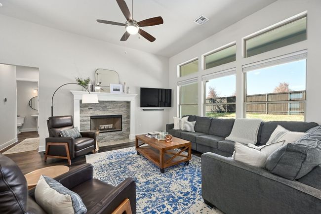 The main floor features an open-concept living room with high ceilings and large windows, filling the space with natural light. | Image 7