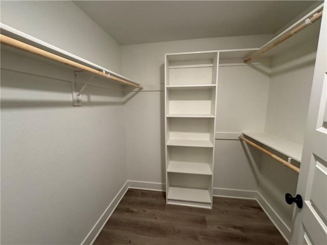 Spacious closet with dark wood-style flooring | Image 63