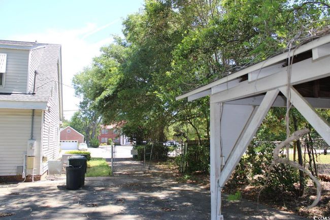 View of side of home with fence and a shingled roof | Image 5