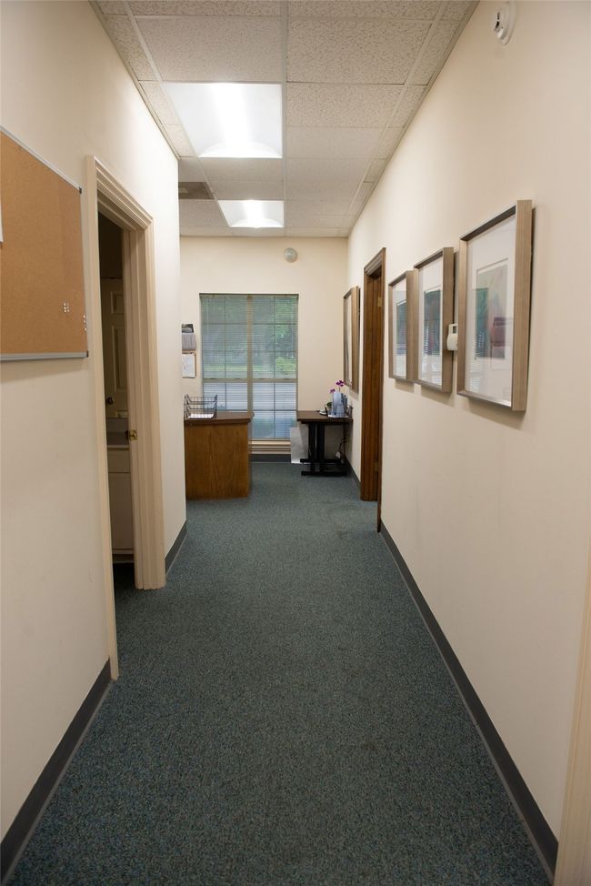 Hallway featuring dark carpet, a drop ceiling, and baseboards | Image 8