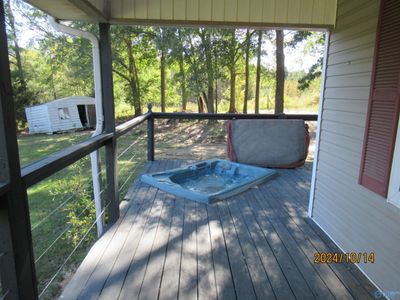 The porches wrap around the home. There is a hot tub on the front side porch. | Image 3