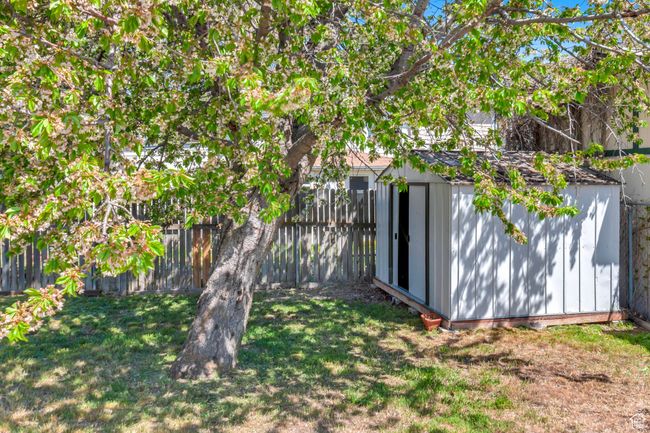 View of yard featuring a storage shed, an outbuilding, and a fenced backyard | Image 28