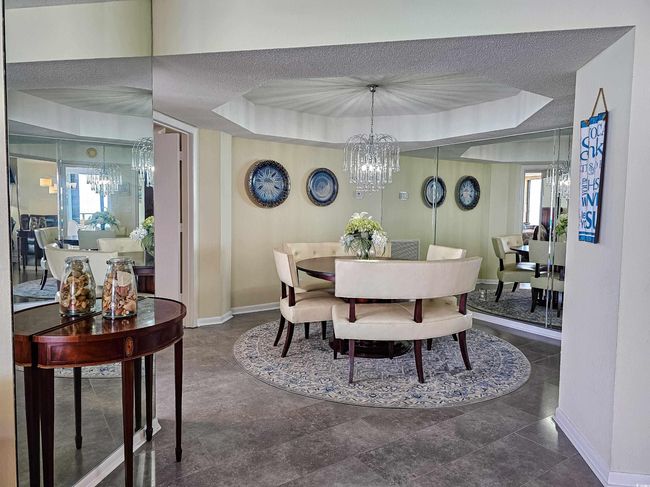Dining space with a chandelier, a tray ceiling, healthy amount of natural light, and a textured ceiling | Image 13