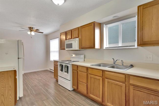 Kitchen with sink, white appliances, LVP flooring, a textured ceiling | Image 7