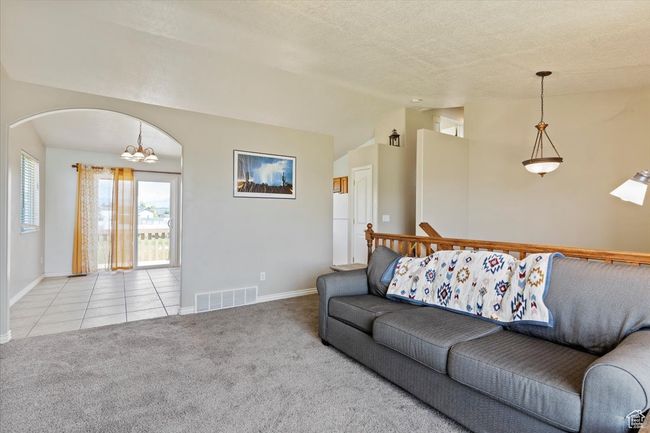 Living room featuring carpet floors, baseboards, and a vaulted ceiling | Image 5