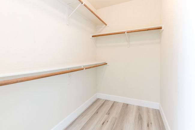 Spacious closet with light wood-type flooring | Image 13