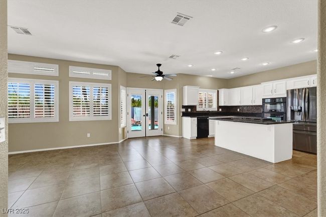 Kitchen featuring black appliances, french doors, plenty of natural light, open floor plan, and recessed lighting | Image 8