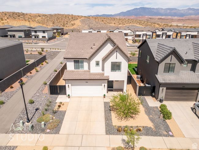 View of front of home featuring a residential view, concrete driveway, an attached garage, and stucco siding | Image 42