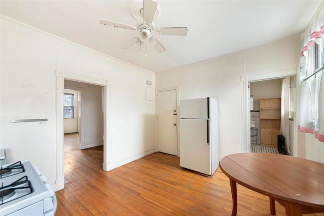 Kitchen with white appliances, baseboards, ceiling fan, and light wood finished floors | Image 13