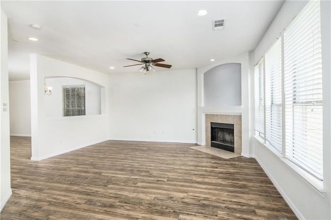 Unfurnished living room featuring recessed lighting, a ceiling fan, a fireplace, and dark wood finished floors | Image 10