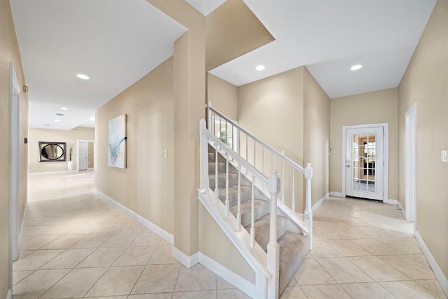 This home features dual staircases, with one located in the entry hall and a second situated conveniently near the kitchen. | Image 21