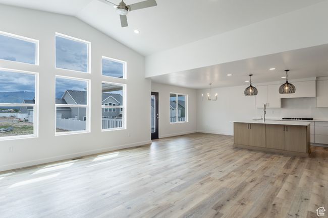 Unfurnished living room with a sink, a chandelier, a ceiling fan, light wood-type flooring, and recessed lighting | Image 7