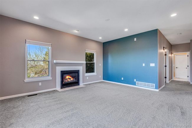 Unfurnished living room featuring plenty of natural light, baseboards, visible vents, and carpet floors | Image 9