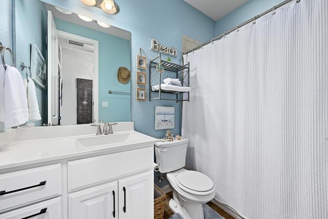 Full bath featuring a textured wall, vanity, wood finished floors, and curtained shower | Image 22