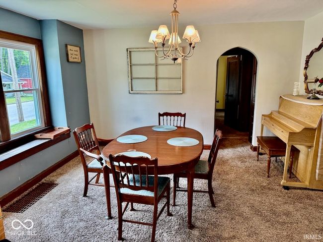 dining area with carpet, arched walkways, plenty of natural light, and a chandelier | Image 14