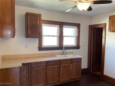 Kitchen with dark wood-type flooring, ceiling fan, and sink | Image 3