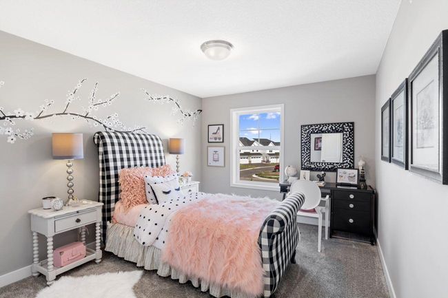 (Photo of a decorated model, actual homes finishes will vary) One of two generously sized upper level secondary bedrooms with spacious closets. | Image 13