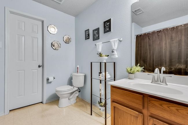 Full bath featuring visible vents, toilet, vanity, and a textured ceiling | Image 13