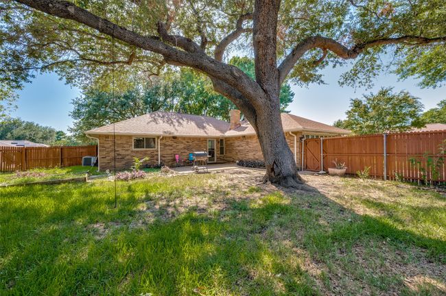 Back of house featuring brick siding, a fenced backyard, a patio area, and a chimney | Image 25