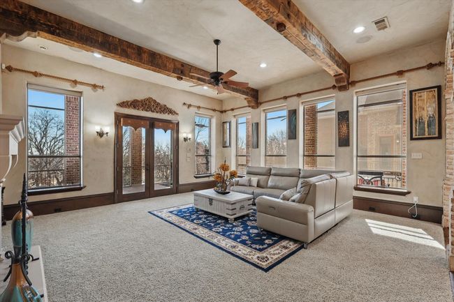 The main floor living room flows seamlessly onto the covered and screened in patio. | Image 11