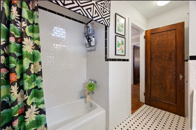 Full bath featuring shower / bath combo with shower curtain and tile walls | Image 21