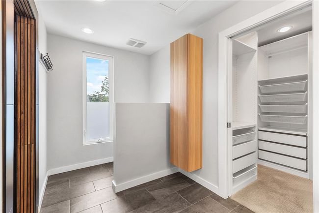 Spacious closet with dark tile patterned floors | Image 18