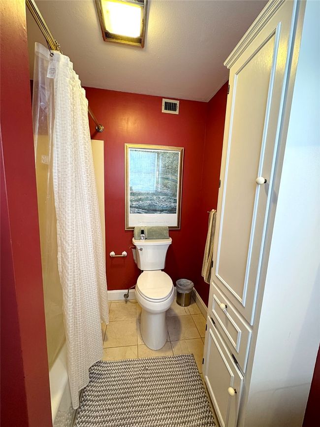 Bathroom featuring toilet, tile patterned flooring, and shower / bath combo | Image 32