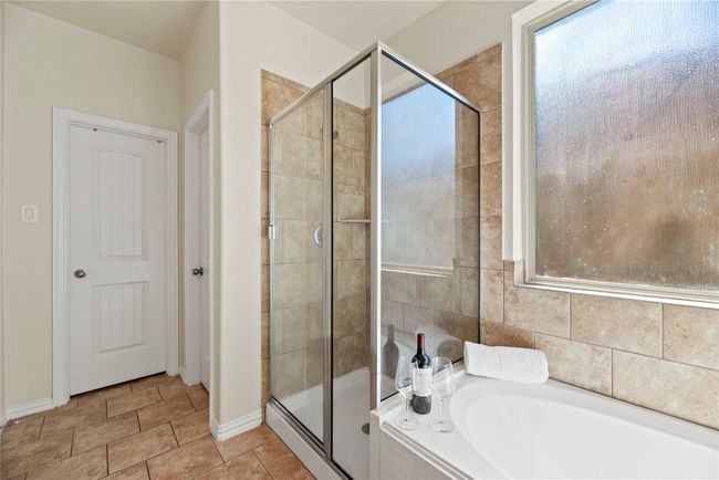 Matching tile work in the shower provides consistency in design. | Image 17