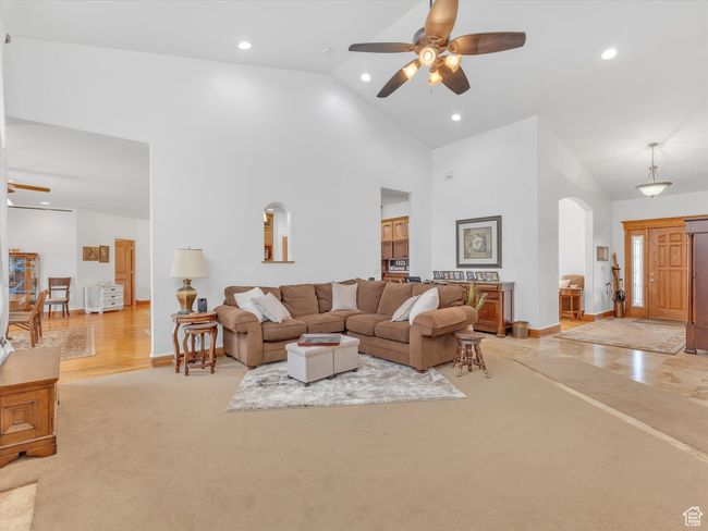 Living room with high vaulted ceiling, ceiling fan, arched walkways, and recessed lighting | Image 8