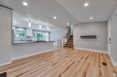 Unfurnished living room with light hardwood / wood-style floors and vaulted ceiling | Image 3