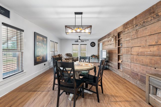 Dining area featuring wood walls, baseboards, light wood-style floors, and ceiling fan | Image 6
