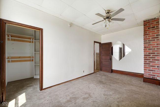 unfurnished bedroom with carpet, a paneled ceiling, and ceiling fan | Image 14