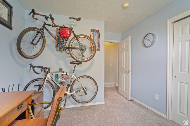 Interior space featuring a textured ceiling, visible vents, and baseboards | Image 18