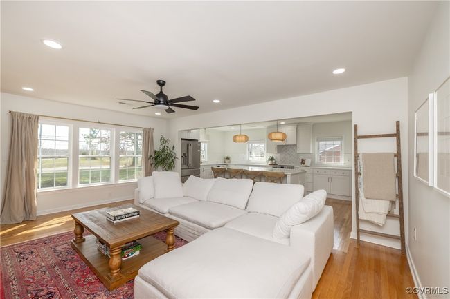 Living room with a ceiling fan, light wood-style flooring, plenty of natural light, and recessed lighting | Image 7