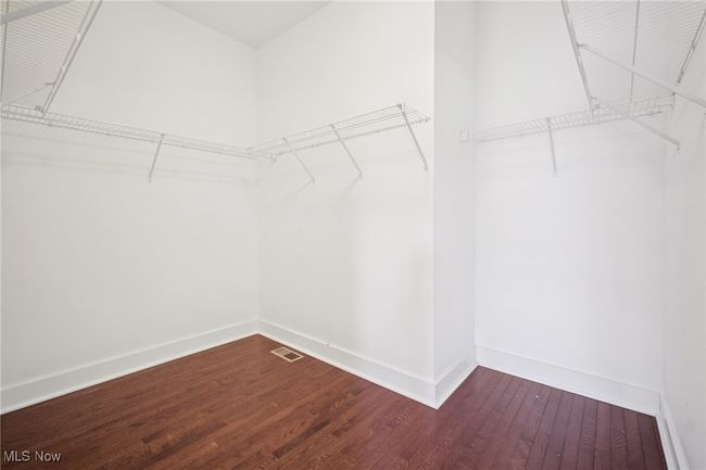 Spacious closet with visible vents and wood-type flooring | Image 17