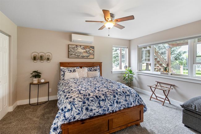 Carpeted bedroom featuring a wall mounted air conditioner and ceiling fan | Image 31