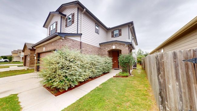 View of front of property featuring fence, a garage, a front lawn, and brick siding | Image 4
