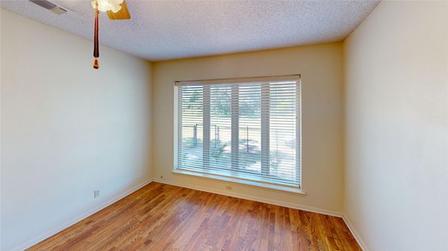 Unfurnished room featuring baseboards, light wood-style flooring, a textured ceiling, and ceiling fan | Image 8