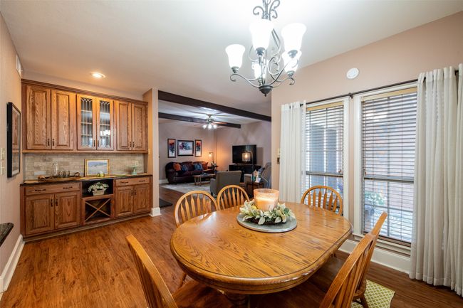 Dining area featuring wood finished floors, a chandelier, and a ceiling fan | Image 9