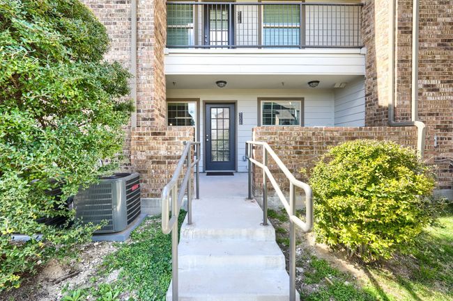 View of exterior entry with a balcony, cooling unit, and brick siding | Image 5